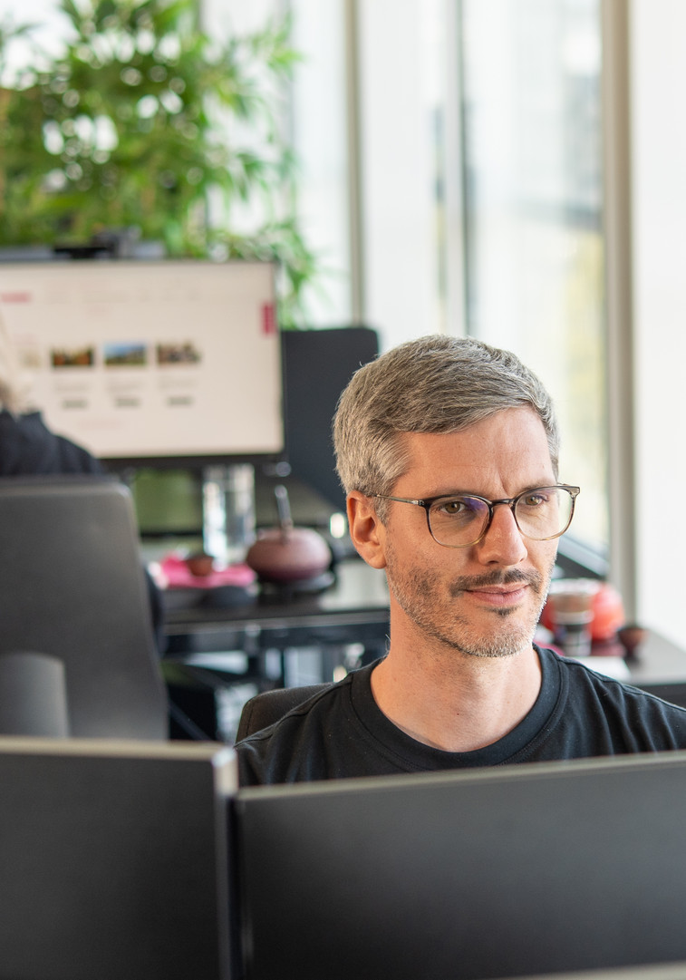 Eine Frau beugt sich über einen Tisch und gibt ihrem Gegenüber die Hand